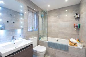 a bathroom with a toilet and a sink and a shower at Sandpiper Cottages in Newquay +36 photos