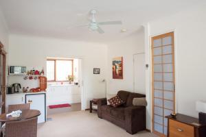 a living room with a couch and a kitchen at TorquayToongahra BnB in Torquay