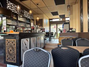ein Restaurant mit einer Bar mit Stühlen und einem Tisch in der Unterkunft Hôtel OpalOriental Boulogne Sur Mer - gare ville et centre in Boulogne-sur-Mer