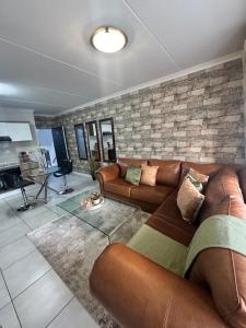 a living room with a couch and a brick wall at The lagoon retreat in Avondzon