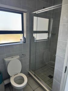a bathroom with a toilet and a glass shower at The lagoon retreat in Avondzon +5 photos