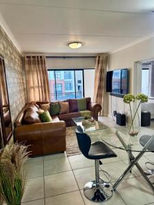 a living room with a couch and a glass table at The lagoon retreat in Avondzon