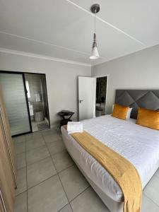 a bedroom with a large bed with orange pillows at The lagoon retreat in Avondzon