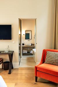 a living room with a red chair and a desk at Hotel FRANQ in Antwerp
