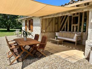 a patio with a table and chairs and a couch at Le Grand Chene in Moustier