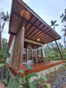 a house with a wooden porch with a roof at Rinjani Vibe Bungalows in Tetebatu