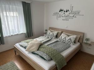 ein Schlafzimmer mit zwei Betten und grünen und weißen Kissen in der Unterkunft Ferienwohnung Eifler in Lam