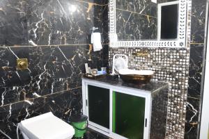 a black and white bathroom with a sink and a toilet at arham farm in Jāmb