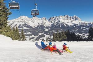 a group of people sitting on a ski lift in the snow at Mountain Residence in Going am Wilden Kaiser