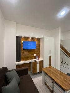 a living room with a couch and a flat screen tv at Alishba Hotel And Restaurant in Lālbāgh