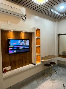 a room with two stools and a tv on a wall at Alishba Hotel And Restaurant in Lālbāgh +31 photos