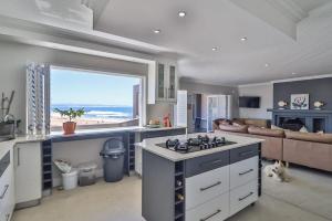 a kitchen with a stove and a living room at Central, Beachfront Home in Jeffreys Bay