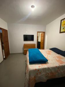 a bedroom with a bed and a tv on the wall at Casa amarela in Santana do Riacho +20 photos