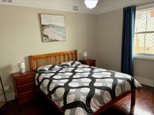 ein Schlafzimmer mit einem Bett mit einer schwarz-weißen Bettdecke in der Unterkunft The Gregory in Geraldton