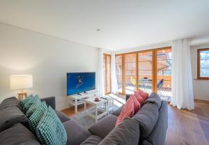 a living room with a couch with colorful pillows at Panoramapark Soleil E 3 in Wengen