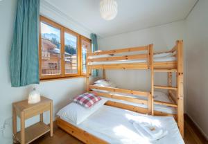 a bedroom with two bunk beds and a window at Panoramapark Soleil E 3 in Wengen