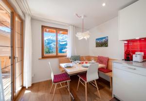 a kitchen with a table and chairs in a kitchen at Panoramapark Soleil E 3 in Wengen
