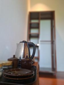 a tea kettle and two cups on a stove at Rinjani Vibe Bungalows in Tetebatu