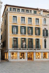a building with a person standing on a balcony at Bellevue Luxury Rooms - San Marco Luxury in Venice