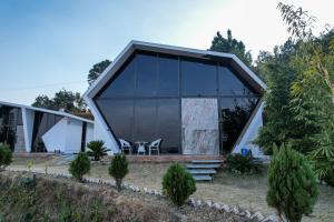 a modern house with a glass facade at SaffronStays Luna Celeste in Rānīkhet