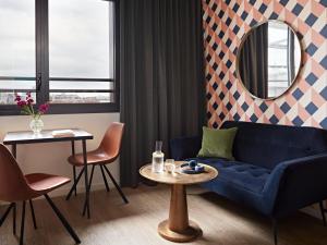 a living room with a blue couch and a table at YAYS Paris Issy by Numa in Issy-les-Moulineaux