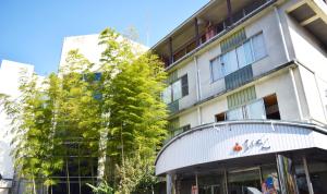 a building with a tree in front of it at Ryokan Fukuzen in Shibukawa