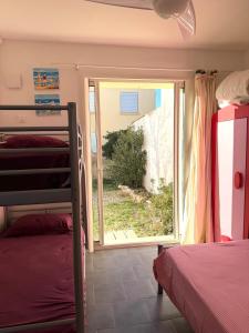 a bedroom with a bunk bed and a sliding glass door at Vue Mer - appartement de charme - accès direct plage in Leucate-Plage