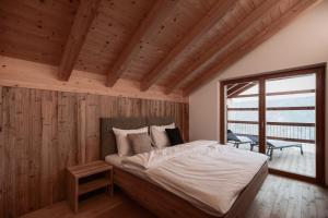 a bedroom with a bed in a room with wooden walls at Deluxe Apartments Lantl in Falzes