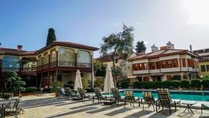 a group of chairs and umbrellas in front of a house at RuinAdalia Hotel in Antalya