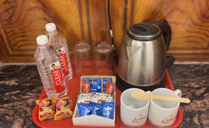 a tray with a coffee pot and some food and drinks at Solitude, The Boutique Hotel- Ultra Luxurious in Haldwāni