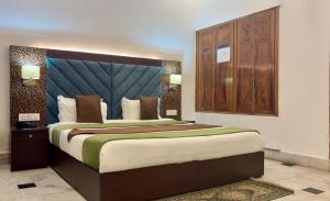 a bedroom with a large bed with a large headboard at Solitude, The Boutique Hotel- Ultra Luxurious in Haldwāni