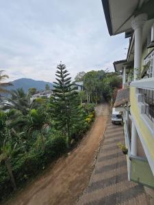 a dirt road next to a house with trees at Hotel Blue Mount View Kandy in Kandy