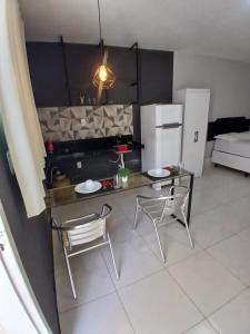 a kitchen with a table and two chairs and a refrigerator at Pousada Flat Lourdes Residence in Angicos