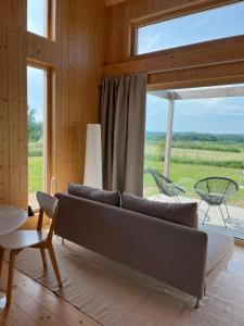 ein Wohnzimmer mit Sofa und großem Fenster in der Unterkunft Slowcabin in Retowo
