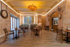 a restaurant with tables and chairs and a clock on the wall at RuinAdalia Hotel in Antalya