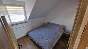 a small bedroom with a bed and a window at Apartament nr 1 Pod Złotym Groniem in Istebna