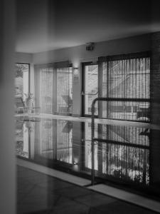 a room with a balcony with windows and a staircase at Simon - das Vitalhotel in Bad Tatzmannsdorf