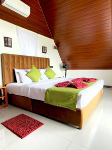 a bedroom with a large bed with a wooden headboard at Cloudy Hill Cottage in Ella