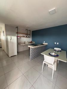 a kitchen with a table and a white refrigerator at Pousada Flat Lourdes Residence in Angicos