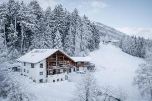 a log cabin in the snow with trees at Deluxe Apartments Lantl in Falzes