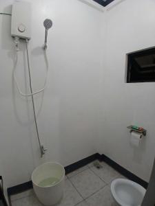 a bathroom with a shower and two toilets at correashomestay in Coron