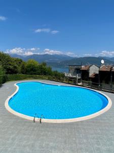 two people are standing in a large blue swimming pool at Refugio Azul Baveno, pool and private parking in Baveno