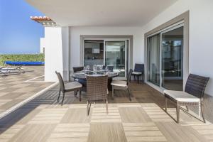 a dining room with a table and chairs at Villa del Rey II in Casal da Lagoa Seca