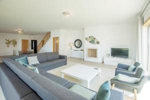 a living room with a couch and chairs and a tv at Villa del Rey III in Casal da Lagoa Seca