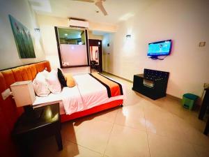 a hotel room with a bed and a television at Laya Beach in Wadduwa