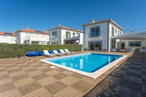a swimming pool in the backyard of a house at Villa del Rey VIII in Casal da Lagoa Seca
