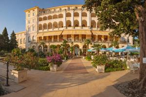 a large building with tables and chairs in front of it at Hotel Kvarner Palace in Crikvenica