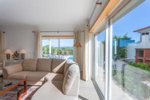 a living room with a couch and a large window at Villa del Rey VII in Casal da Lagoa Seca