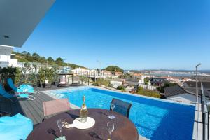 a bottle of wine on a table next to a swimming pool at Villa Sao Martinho in São Martinho do Porto