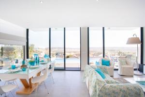 a dining room with a table and chairs and glass windows at Villa Sao Martinho in São Martinho do Porto